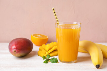 Composition with fresh juice and tropical fruits on color background