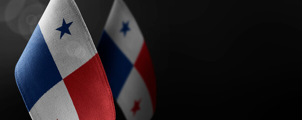 Small national flags of the Panama on a dark background