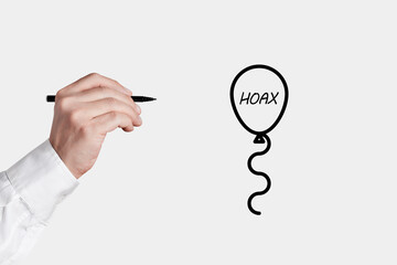 Businessman with a pen is about to pop a balloon icon with the word hoax. Revealing the facts