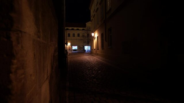 street lantern lighting in an empty dark street on the square with cobblestones in the center of the old town of Prague at night 2021
