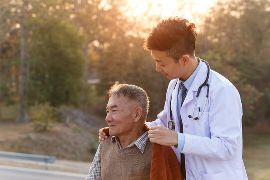 Asian Old Man Is Having Doctor Meeting At Garden, Health Care Assistants, Insurance Agent And Financial Advisor Service.