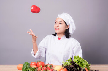Portrait of a young Asian female chef ready to cook a new dish in the kitchen. 