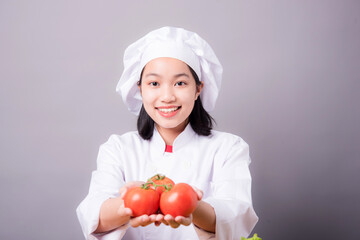 Portrait of a young Asian female chef ready to cook a new dish in the kitchen. 