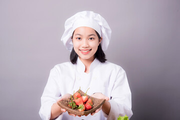 Portrait of a young Asian female chef ready to cook a new dish in the kitchen. Contains Strawberry as an ingredient