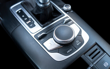 Media and navigation control buttons of a modern car. Car interior details. Black leather interior of the luxury modern car. Car detailing