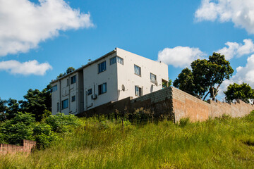 Fototapeta na wymiar Residential Dwelling Constructed on top of Grassy Hill