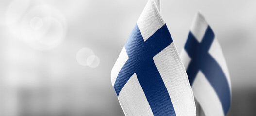 Small national flags of the Finland on a light blurry background