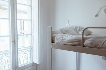 white bunk bed near window in white room