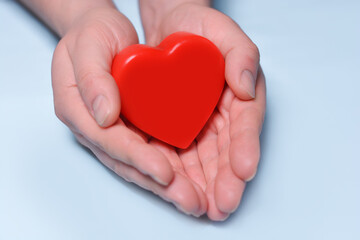 Red heart in man's hands isolated on blue background. Healthcare and hospital medical concept. Symbolic of Valentine day.Top view with space for text.