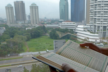 Muslim man holding open the Quran on his hands