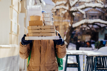 Delivery employee man at thermal takeaway food bag backpack pizza boxes work courier service concept. Outdoor winter portrait.