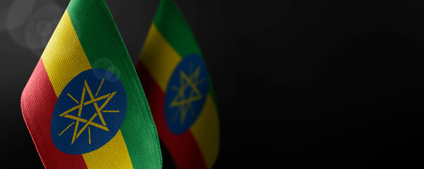 Small national flags of the Ethiopia on a dark background