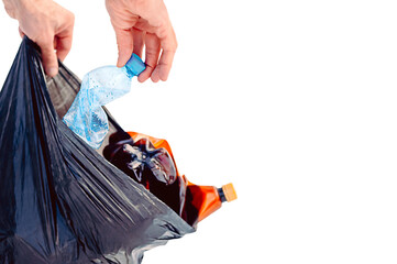 Plastic Pollution, Plastic waste problem, synthetic plastic products in the environment. Mans hand putting plastic bottles in trash bag