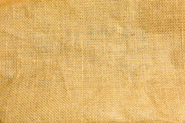 Fototapeta na wymiar The texture of burlap, rough weave in a cage made of natural fiber, yellow-brown color. Copyspace, close-up