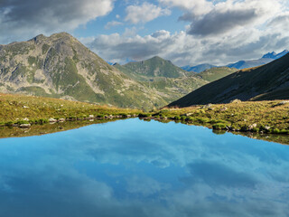 Naklejka na ściany i meble Mountain lake view with reflection of clouds
