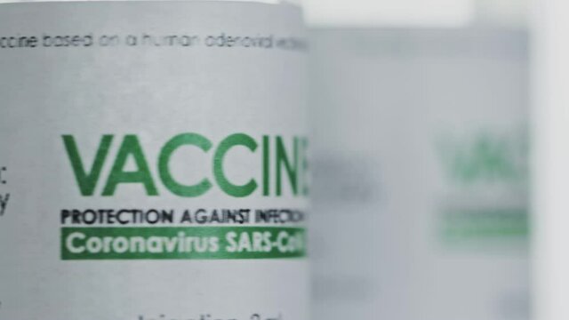 Looped. Vials of vaccine for COVID-19 coronavirus cure are slowly rotated in research lab. Vaccination, injection, clinical trial during pandemic. Flacons, vials are spinning clockwise. Closeup macro