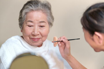 化粧をしてもらうおばあちゃん　メイクをしてもらう高齢女性