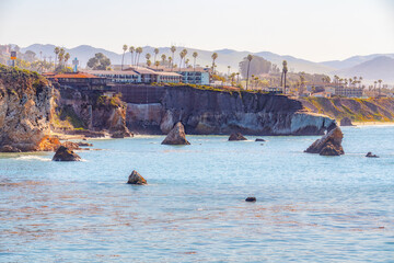 Pismo Beach cliffs with palm trees,  and silhouette of hotels overlooking the Pacific Ocean. San...