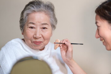 化粧をしてもらうおばあちゃん　メイクをしてもらう高齢女性 - obrazy, fototapety, plakaty