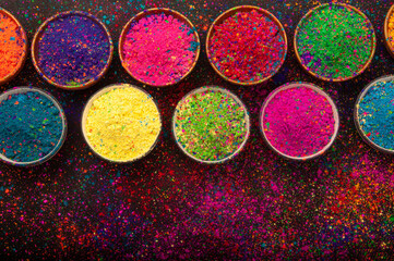 Holi color powder. Organic Gulal colours in bowl for Holi festival, Hindu tradition festive. isolated on black background