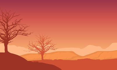 A beautiful view of the afternoon sky at dusk with the silhouette of the mountains and dry trees around it. Vector illustration