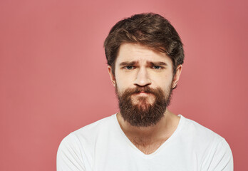 Obraz premium Man on a pink background portrait white t-shirt bushy beard