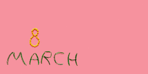 The inscription March 8 yellow flowers and green mimosa leaves lies on the pink background of the international women's day holiday spring horizontal wide banner soft focus free space for text