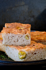 Pieces of fresh soft moist sourdough focaccia with green olives