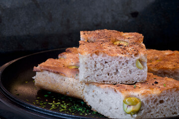 Pieces of fresh soft moist sourdough focaccia with green olives