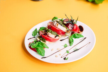 Caprese salad. Tomatoes, mozzarella, basil, pesto, balsamic sauce