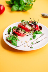 Caprese salad. Tomatoes, mozzarella, basil, pesto, balsamic sauce