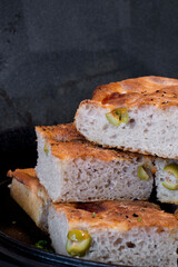 Pieces of fresh soft moist sourdough focaccia with green olives