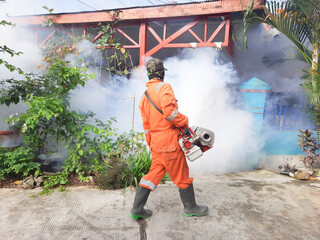 fogging machine spraying chemical to eliminate mosquitoes and prevent dengue fever at general location in community