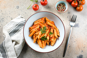 Penne pasta with tomato sause in white plate on stone background table. Top view. Italian food