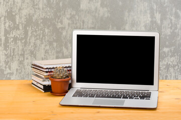 Fototapeta premium Notebook with notebooks and green succulent on a wooden table. mockup for text