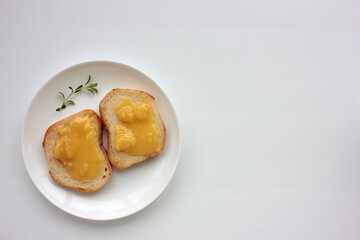 Toast bread with organic honey on plate on white table background. Healthy breakfast concept. Top view, copy space.
