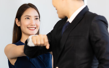 Businessman in suits and woman use elbows touch for greeting each other in the style of new normal people. Health care and safety in office during coronavirus outbreak concept