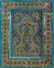 Intricate floral and geometric traditional blue turquoise and yellow tile decoration on facade of medieval mausoleum at Shah-i-Zinda necropolis in UNESCO listed Samarkand, Uzbekistan