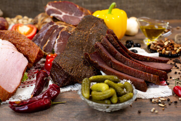 Assortment of cold cuts, a variety of processed cold meat products. On a wooden background