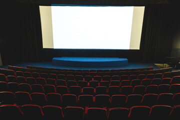 Cinema interior. Chairs in a large empty cinema hall against a white projection screen