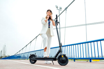 A woman putting on a helmet to use a folding electric scooter © OscarStock