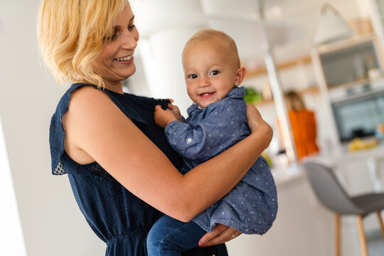 Happy family. Mother and baby daughter plays, hugging, kissing at home