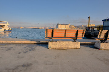 İstanbul. Turkey. 26.02.2021. Street bench in Kadikoy istanbul bosporus shore and haydarpasa main train station and istanbul silhouette background