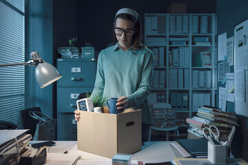 Sad woman packing her belongings in the office