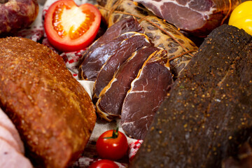 Assortment of cold cuts, a variety of processed cold meat products. On a wooden background