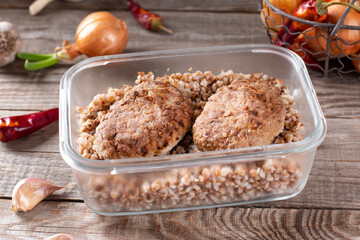 Cutlets and buckwheat in a container ready for freezing