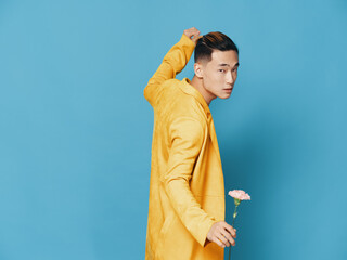 Fototapeta na wymiar man in yellow coat with flower dancing on blue background