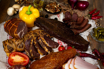 Assortment of cold cuts, a variety of processed cold meat products. On a wooden background