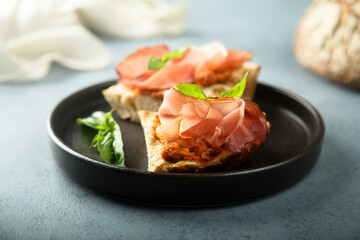 Homemade bruschetta with smoked meat and red pesto