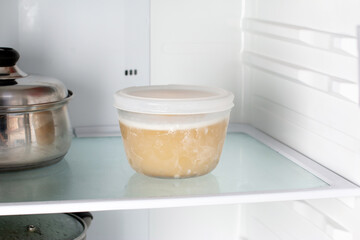 Frozen broth in a container in the freezer